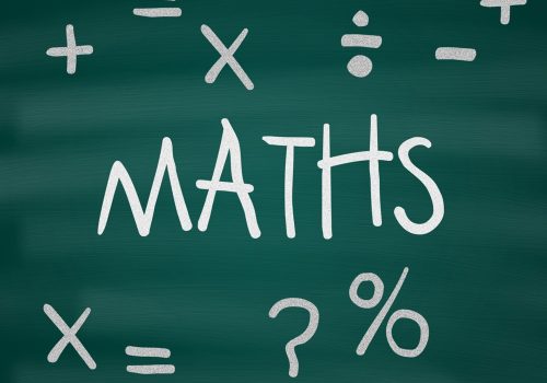 The word Maths, along with mathematical symbols, written on a green chalkboard